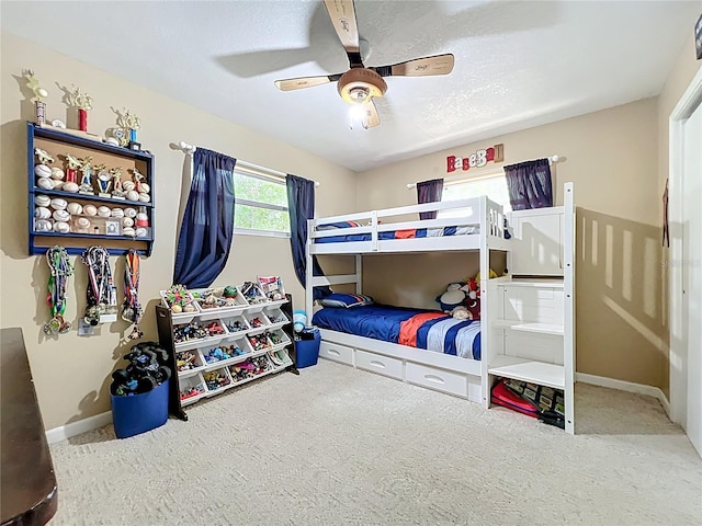 carpeted bedroom featuring baseboards and ceiling fan