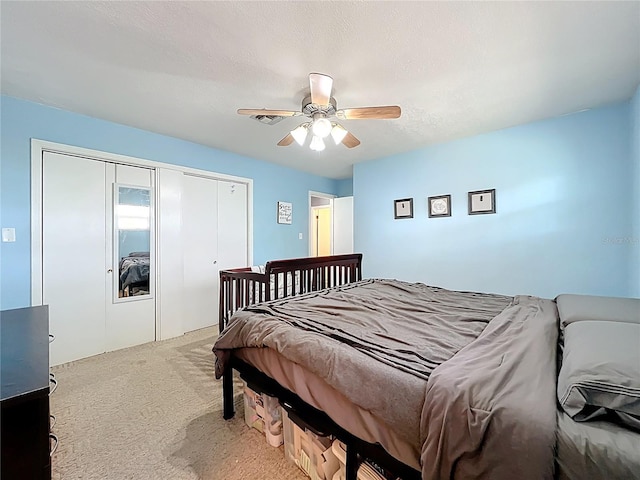 carpeted bedroom with a closet, a textured ceiling, and a ceiling fan