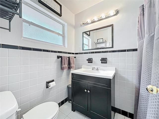 full bathroom with vanity, tile walls, toilet, and tile patterned floors