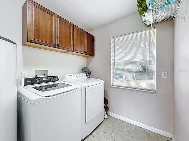 laundry area with light tile patterned floors, baseboards, cabinet space, and independent washer and dryer