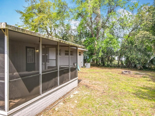 view of yard with central AC unit and a sunroom