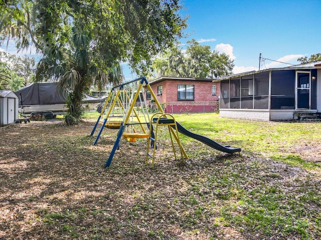 view of play area with a lawn and a sunroom