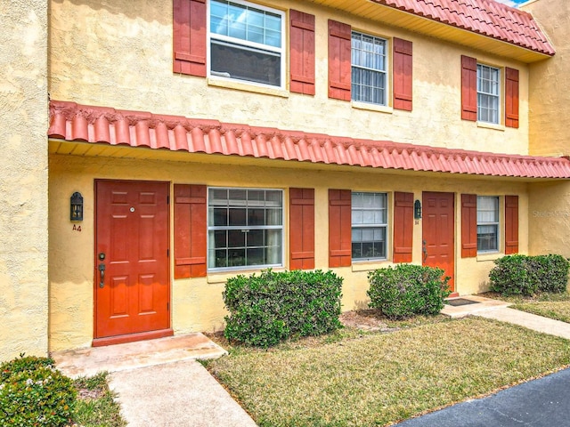 townhome / multi-family property featuring stucco siding and a tiled roof