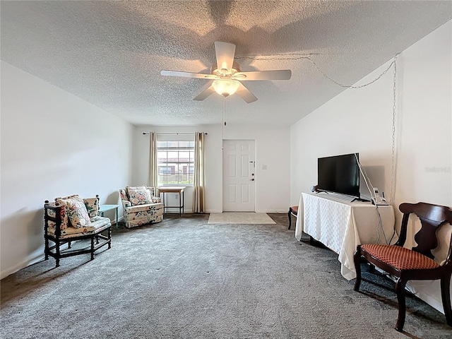 sitting room with baseboards, carpet flooring, a textured ceiling, and a ceiling fan