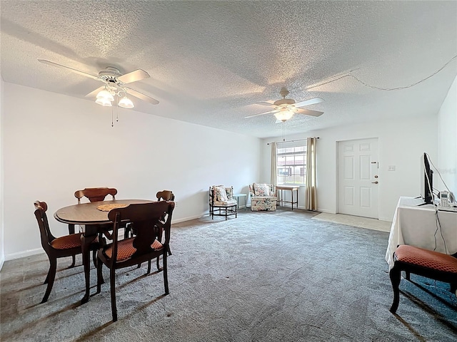 carpeted dining room with a ceiling fan, baseboards, and a textured ceiling