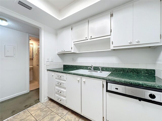 kitchen with a sink, visible vents, dark countertops, and dishwasher