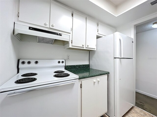 kitchen featuring visible vents, under cabinet range hood, dark countertops, white cabinetry, and white appliances