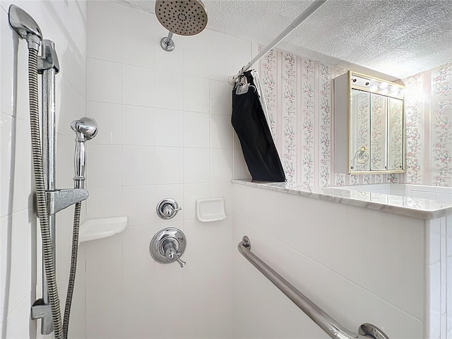 full bathroom featuring a textured ceiling and tiled shower