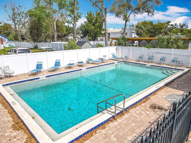 pool featuring area for grilling, a patio, and fence