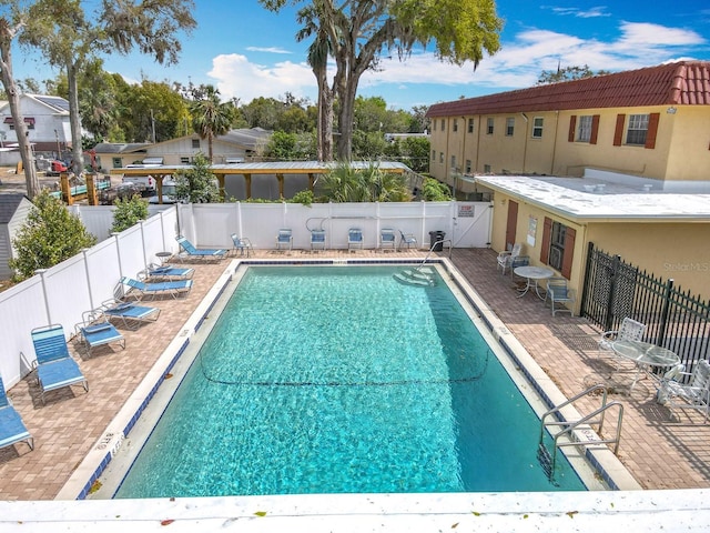 community pool featuring a patio and a fenced backyard