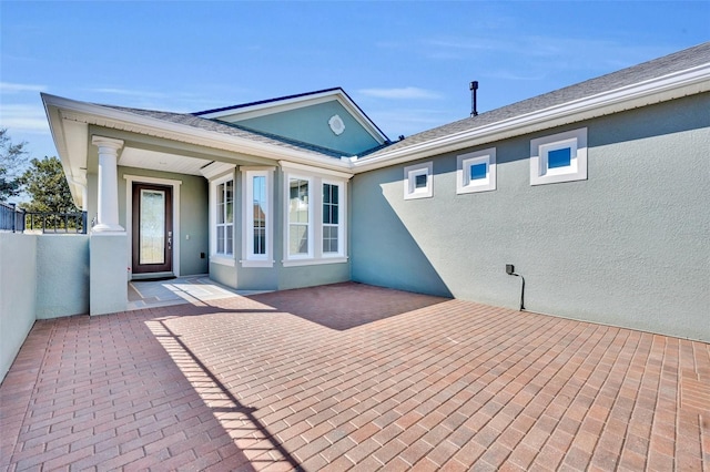 back of property featuring stucco siding and fence