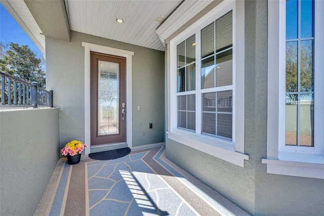 doorway to property featuring stucco siding