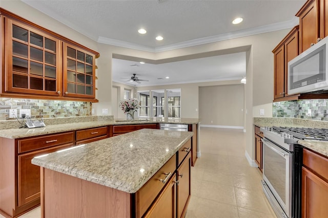 kitchen with appliances with stainless steel finishes, crown molding, and a peninsula