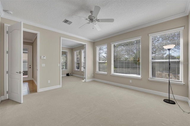 spare room with ceiling fan, light carpet, visible vents, and ornamental molding