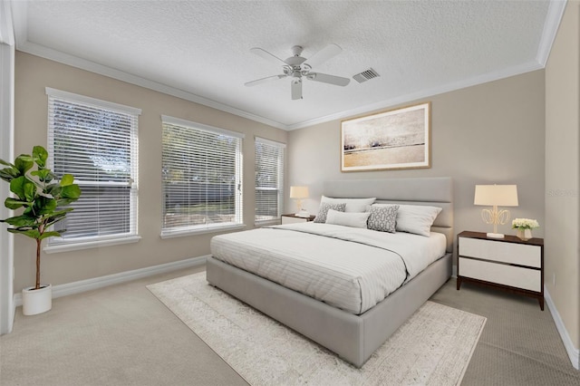 carpeted bedroom featuring visible vents, baseboards, and crown molding