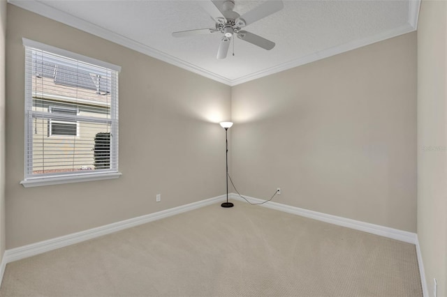 spare room featuring a textured ceiling, carpet flooring, crown molding, baseboards, and ceiling fan