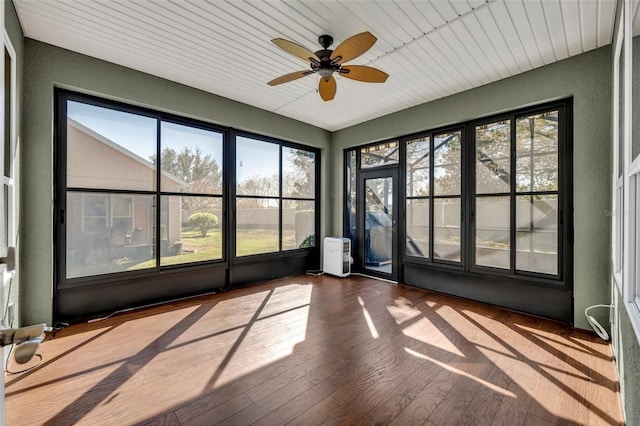 unfurnished sunroom featuring a ceiling fan