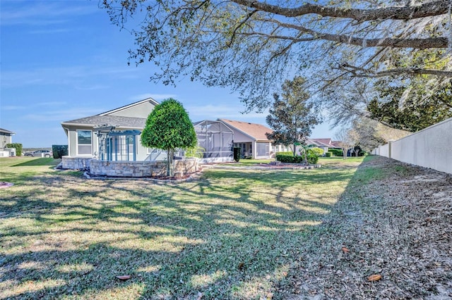 view of yard featuring a lanai and fence