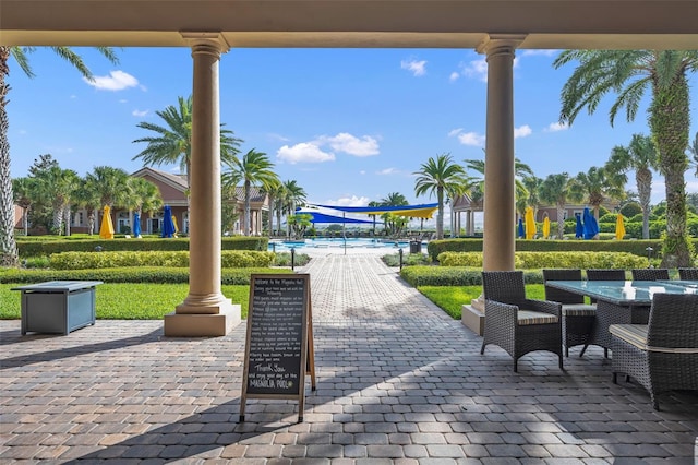 view of patio / terrace with a community pool and outdoor dining space