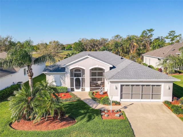 view of front of home featuring a front yard, an attached garage, driveway, and stucco siding