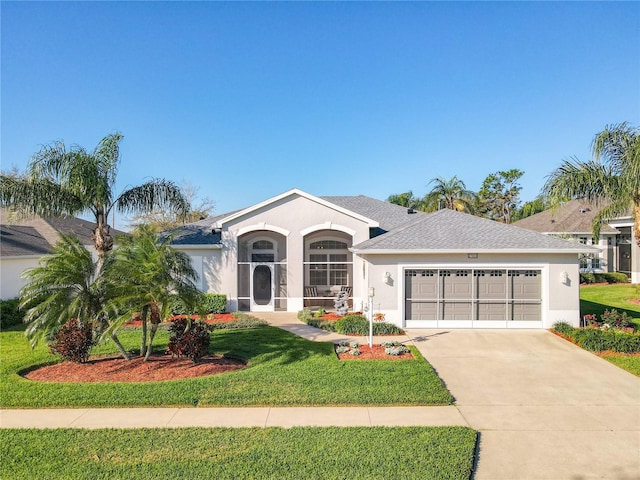 single story home with stucco siding, concrete driveway, a garage, and a front yard