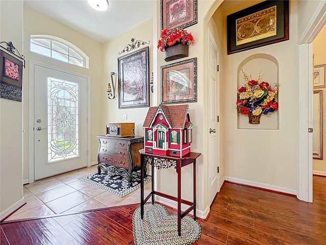 entryway with baseboards, a healthy amount of sunlight, and wood finished floors