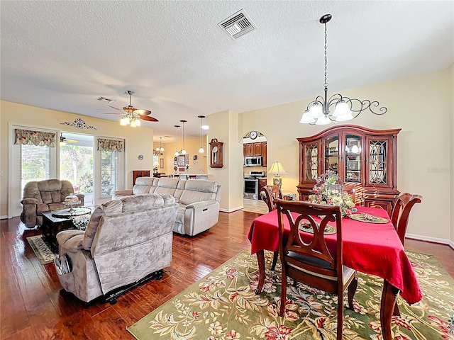 dining room with dark wood-style floors, visible vents, and a textured ceiling