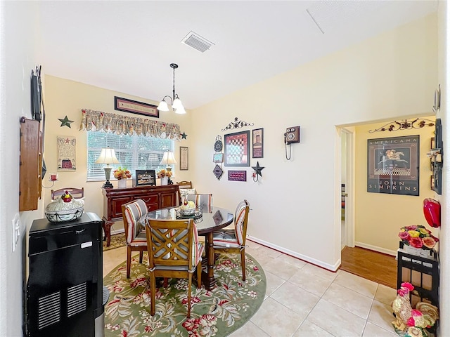 dining space with light tile patterned floors, visible vents, baseboards, and a notable chandelier