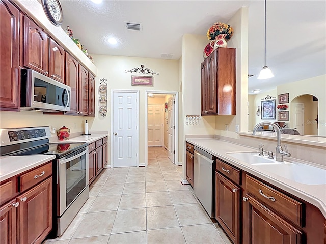 kitchen featuring light tile patterned floors, stainless steel appliances, visible vents, and light countertops