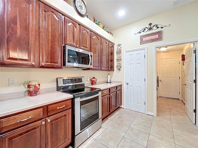 kitchen with light tile patterned floors, visible vents, appliances with stainless steel finishes, and light countertops