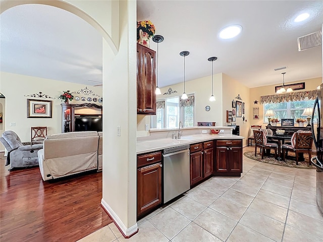 kitchen with visible vents, pendant lighting, a sink, light countertops, and dishwasher