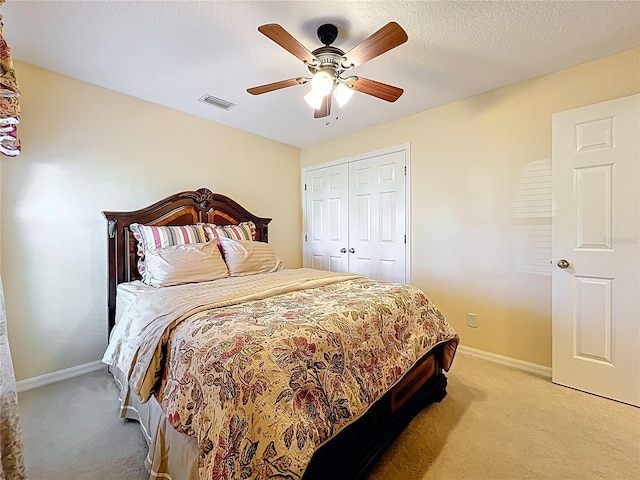 bedroom featuring a closet, visible vents, light colored carpet, and baseboards