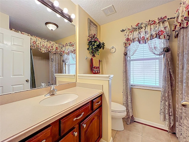 bathroom featuring tile patterned flooring, visible vents, toilet, vanity, and a textured ceiling