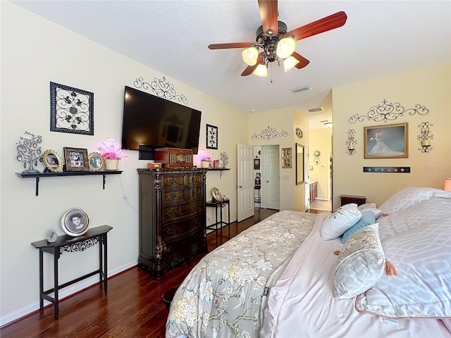 bedroom featuring visible vents, baseboards, wood finished floors, and a ceiling fan