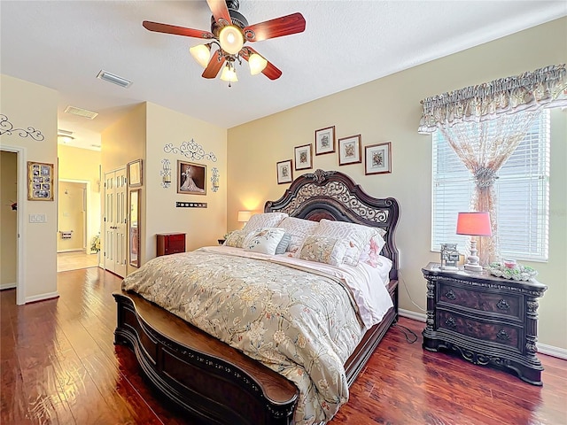 bedroom with visible vents, baseboards, wood finished floors, a closet, and a ceiling fan