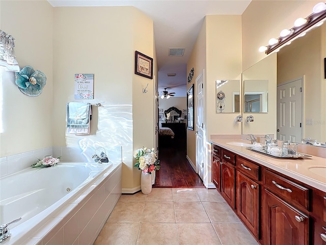 ensuite bathroom with ensuite bath, double vanity, a sink, tile patterned flooring, and a jetted tub