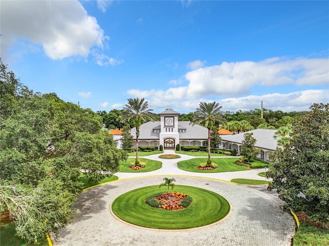 view of community featuring a yard and curved driveway