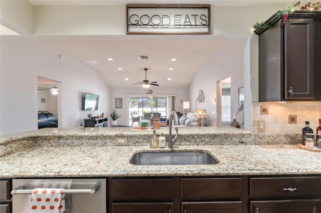 kitchen with ceiling fan, dark brown cabinetry, open floor plan, dishwasher, and a sink