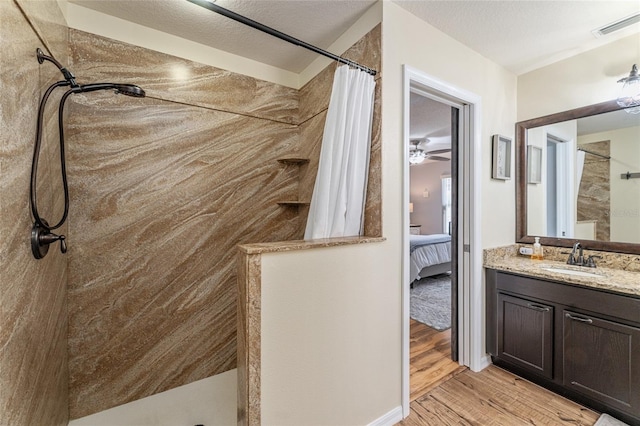 full bath with visible vents, ensuite bath, wood finished floors, walk in shower, and vanity