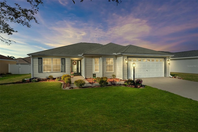 single story home with concrete driveway, an attached garage, fence, and a front yard