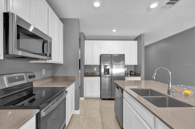 kitchen with a sink, stainless steel appliances, visible vents, and white cabinetry