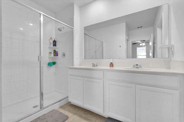 full bathroom with ceiling fan, a shower stall, tile patterned flooring, and a sink