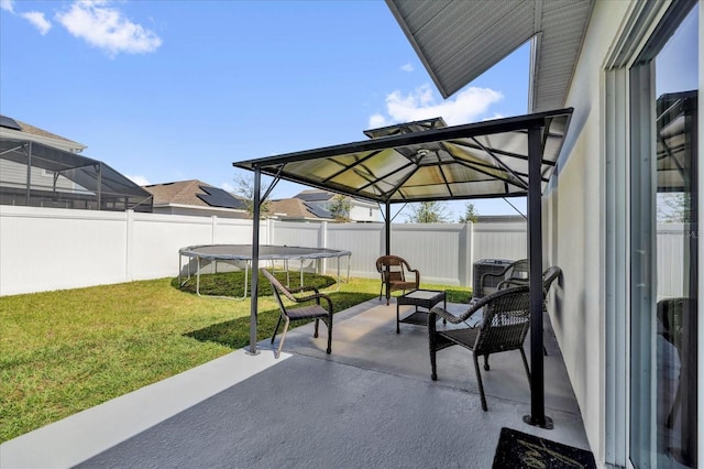 view of patio featuring a trampoline and a fenced backyard