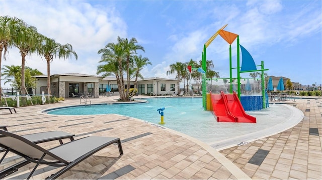 pool with a patio area and fence