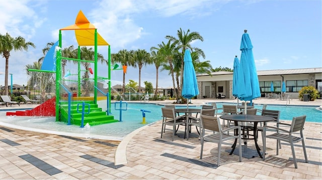 view of play area featuring a community pool, a patio area, and a water play area