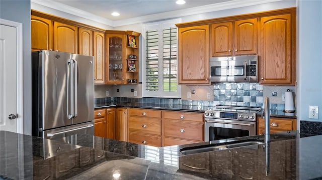 164 Nautica Mile Dr, Clermont, FL 34711 - kitchen with ornamental molding, dark stone countertops, appliances with stainless steel finishes, brown cabinetry, and decorative backsplash