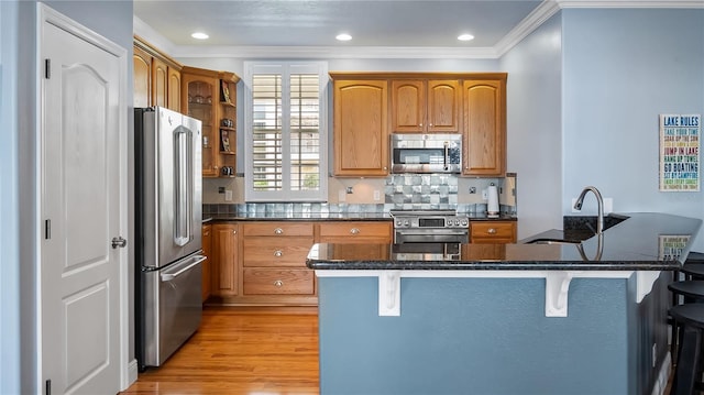 164 Nautica Mile Dr, Clermont, FL 34711 - kitchen featuring light wood-style flooring, a sink, a kitchen breakfast bar, stainless steel appliances, and crown molding