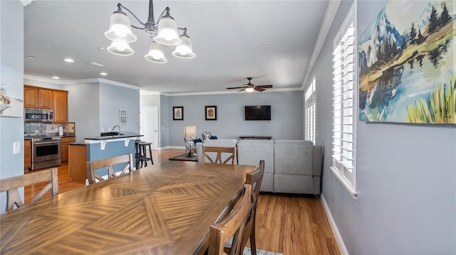 164 Nautica Mile Dr, Clermont, FL 34711 - dining area featuring baseboards, light wood-style flooring, recessed lighting, ornamental molding, and ceiling fan with notable chandelier