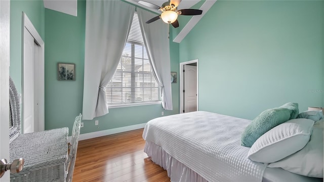 164 Nautica Mile Dr, Clermont, FL 34711 - bedroom with baseboards, wood finished floors, a closet, high vaulted ceiling, and a ceiling fan