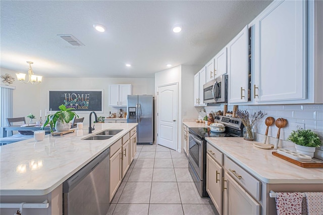 3719 Holly Grove Ln, Mount Dora, FL 32757 - kitchen with appliances with stainless steel finishes, a sink, a chandelier, a center island with sink, and tasteful backsplash